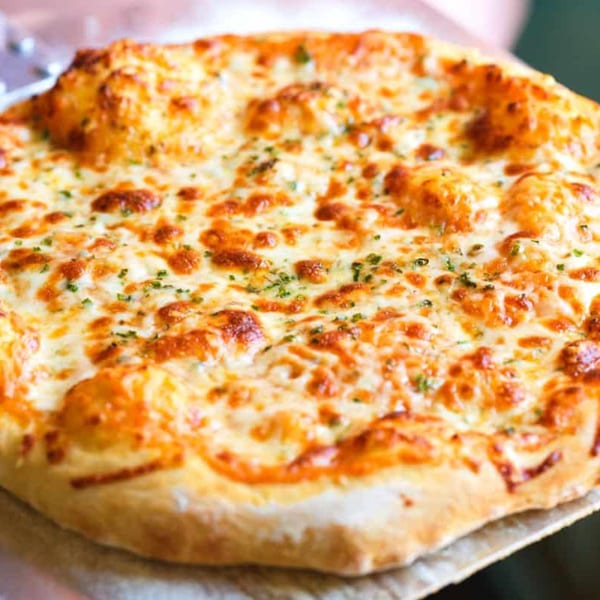 A freshly baked Antonella's Pizzeria cheese pizza with golden crust and melted cheese, garnished with herbs.