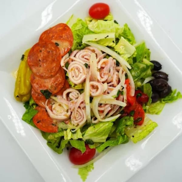 Antonella's Pizzeria Italian salad with pepperoni, rolled ham, olives, tomatoes, and peppers on lettuce.